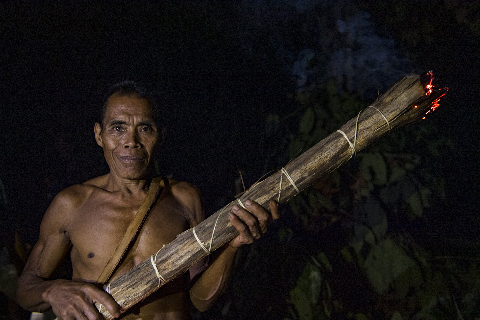 A honey farmer with a smoke torch from the Talang Mamak tribe. The Talang Mamak tribe is one of the tribes whose livelihood is embedded with the forest resources since long time ago through hunting and gathering the forest products. These products will be consumed for their own family or communal. Talang Mamak are spread around Bukit Tigapuluh which is administratively located in Batang Gangsal, Kelayang, and Renga Barat subdistrict as well as Indragiri Hulu district, Riau Province. One of the groups lives in Semerantihan hamlet, Suo-Suo Village, Batang Sumai, Tebo district, Jambi Province.